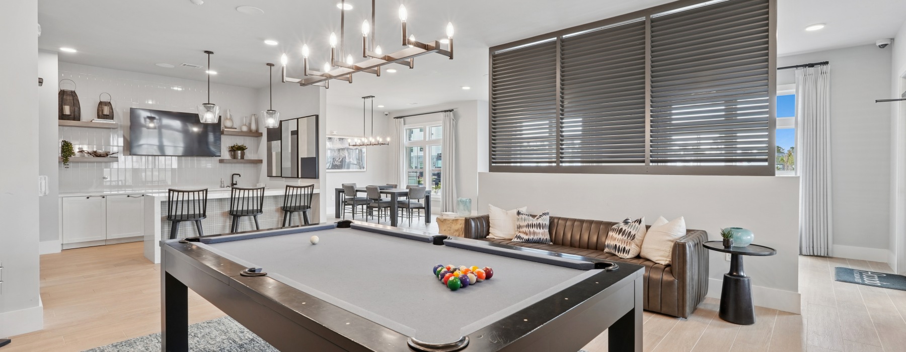 Room with billiards, a bar table, and lounge seating 